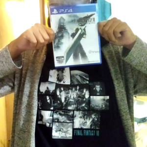 Memegang kaset PS Final Fantasy VII Remake dengan latar belakang kaos Final Fantasy VII